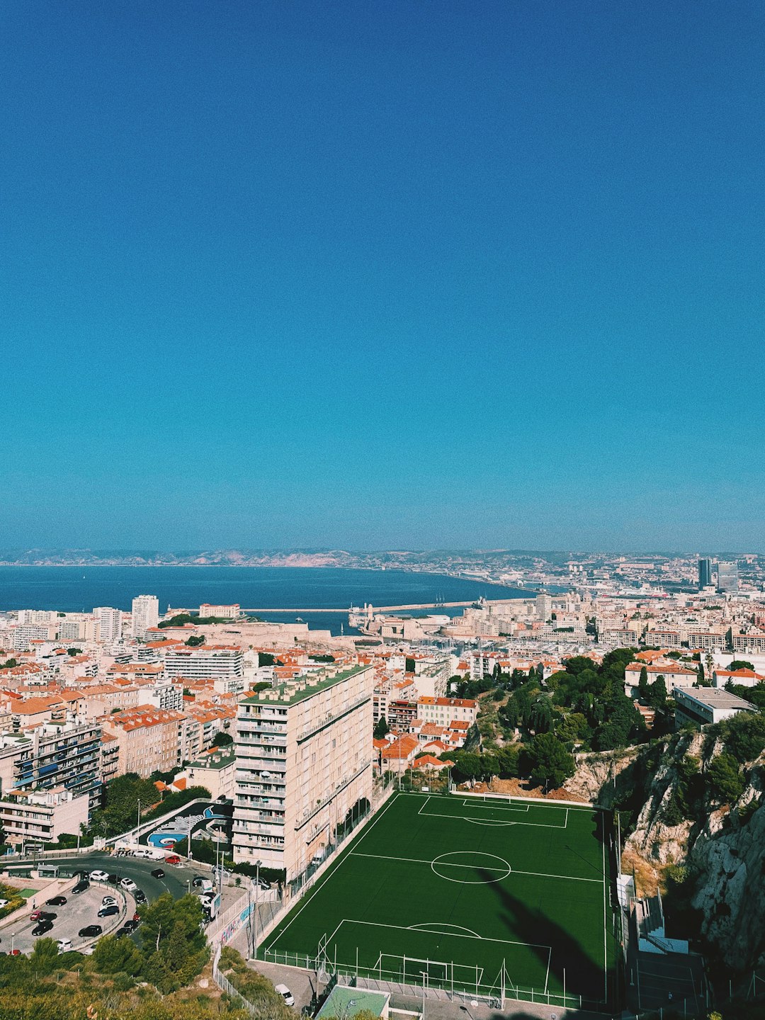 Vue de Marseille depuis les hauteurs, terrain de sport et mer Méditerranée